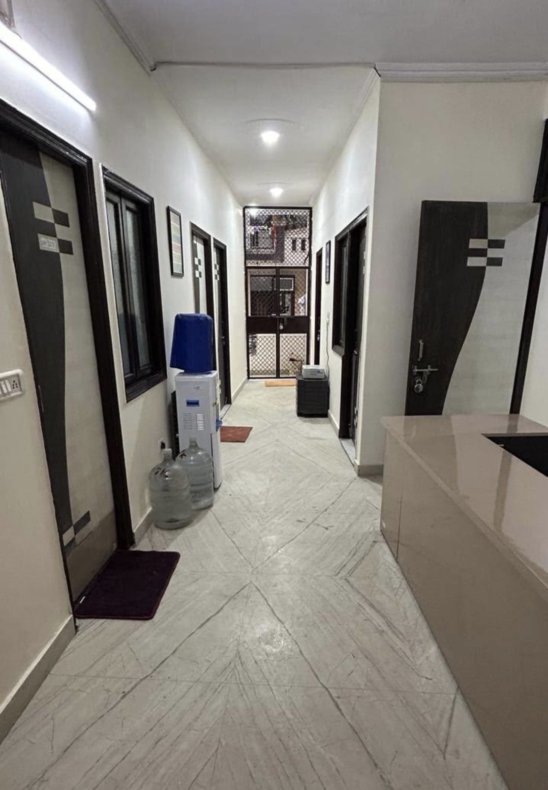 Well-lit corridor with water dispenser between rooms