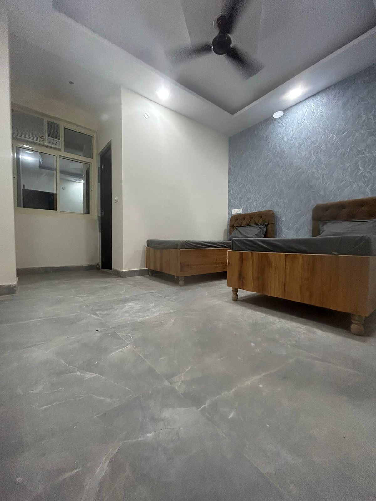 Spacious twin sharing room with textured accent wall